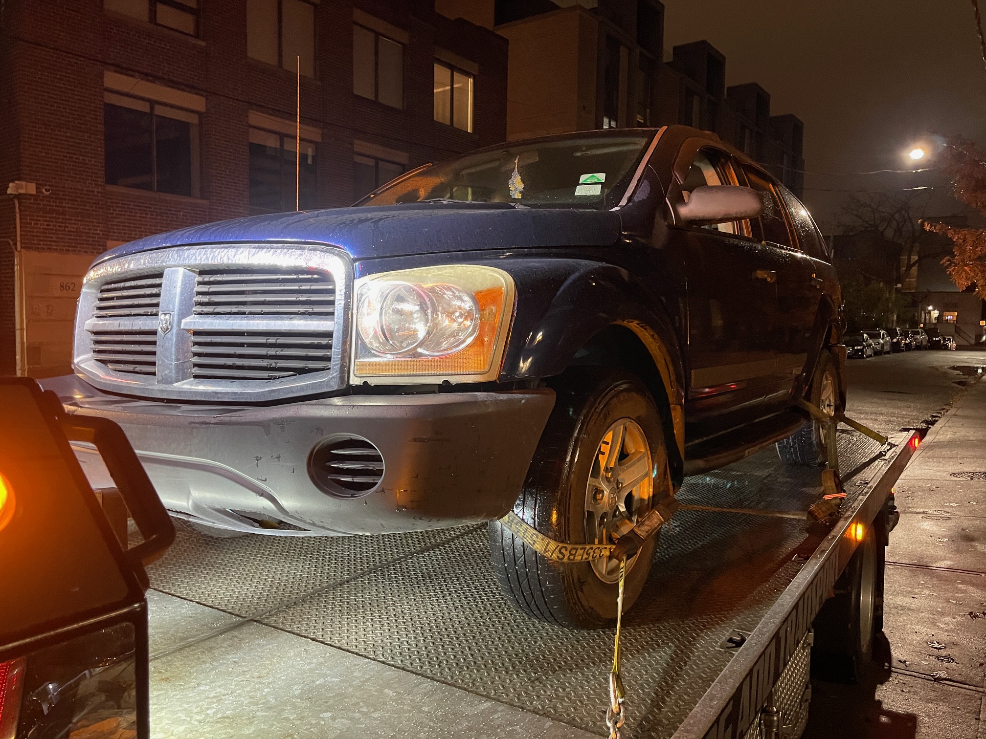 Dodge pickup secured to a flatbed at night in Toronto